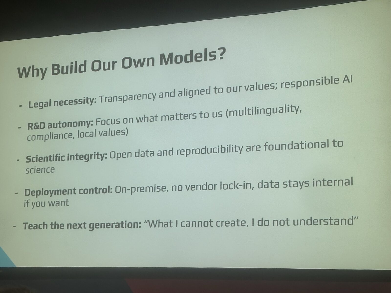 Slide titled 'Why Build Our Own Models?' listing five reasons: Legal necessity (Transparency and aligned to our values, responsible AI); R&D autonomy (Focus on what matters to us: multilinguality, compliance, local values); Scientific integrity (Open data and reproducibility are foundational to science); Deployment control (On-premise, no vendor lock-in, data stays internal if you want); Teach the next generation ('What I cannot create, I do not understand').